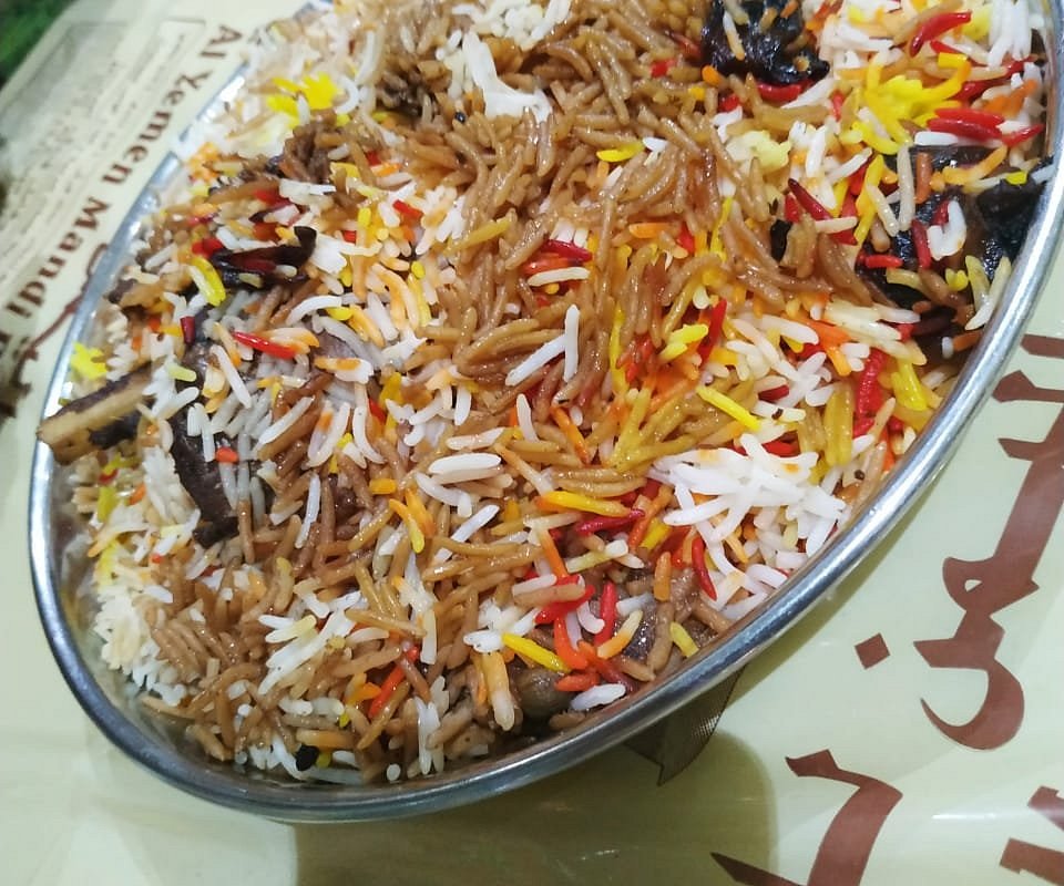A platter of Al Yemen Mandi's signature saffron mandi rice, coloured with red and yellow strands